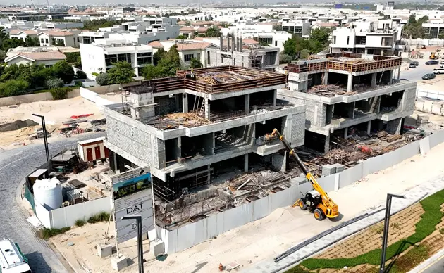 Framers assembling wooden structure of a custom home on a cleared lot