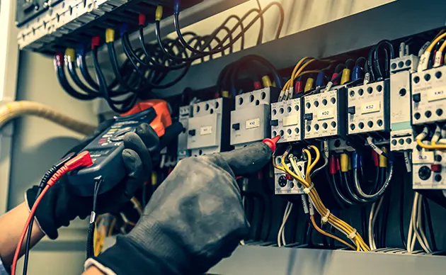 Gloved electrician tightening connections in a household electrical breaker panel