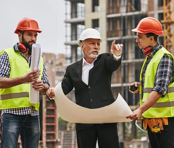 Construction project manager reviewing blueprints with contractors at an Ontario building site